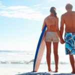 anti aging Maui walking on beach with surf board