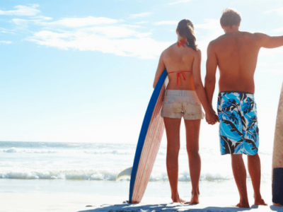 anti aging Maui walking on beach with surf board