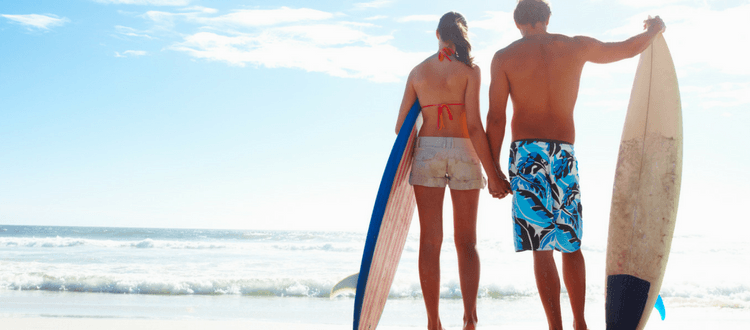 anti aging Maui walking on beach with surf board