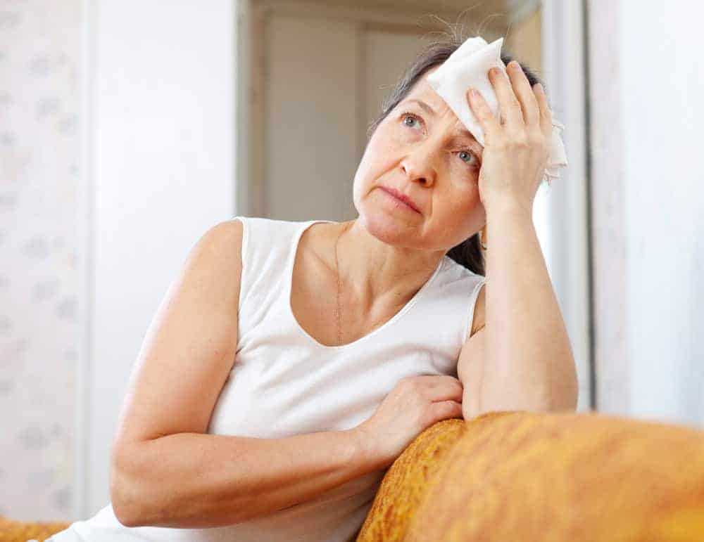 Woman cooling herself during a hot flash