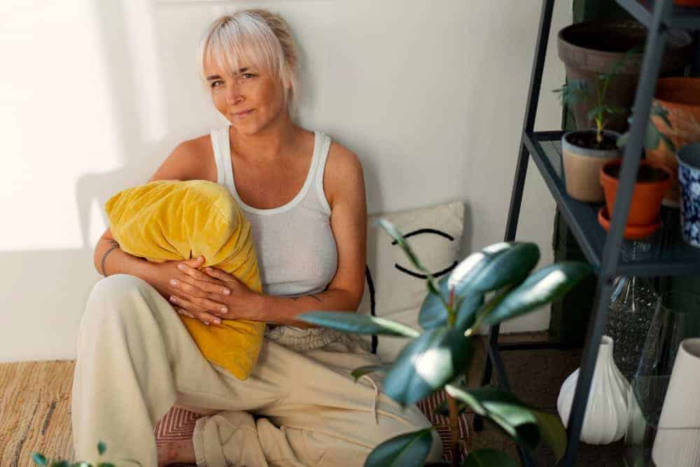 Woman sitting up against a wall